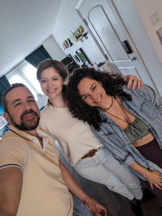 Behind-the-scenes moment at Icon Provocateur: two photographers and a smiling female client pose together in the studio, radiating joy and comfort after a boudoir session.